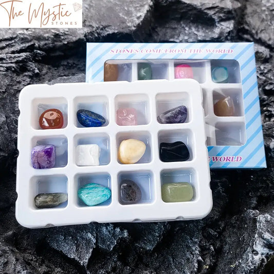 A neatly arranged collection of 12 polished crystal gemstones of various colors and patterns, displayed in a transparent box.