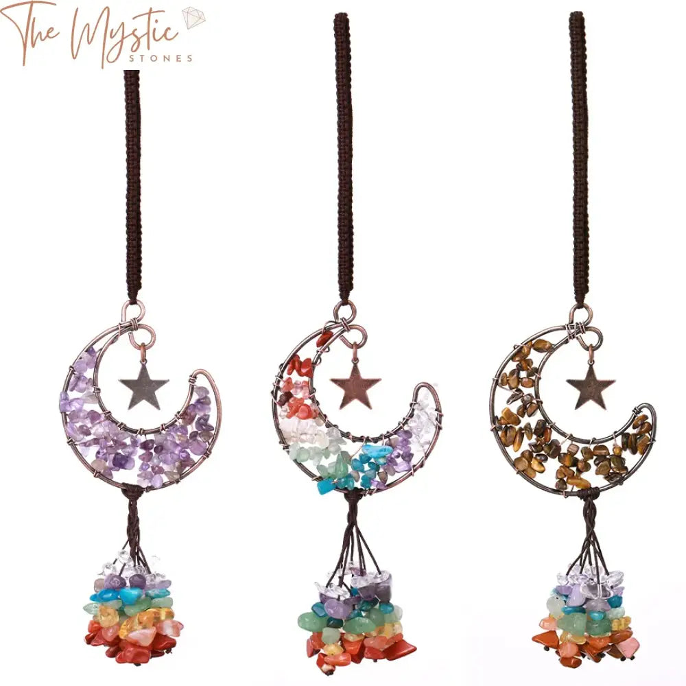 A crescent moon-shaped pendant hangs stylishly, crafted from natural stones that represent the seven chakras.