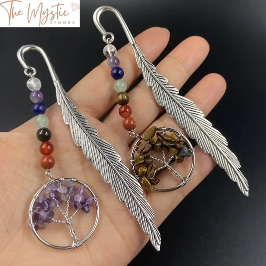 A vintage metal feather bookmark featuring a silver tree of life charm.