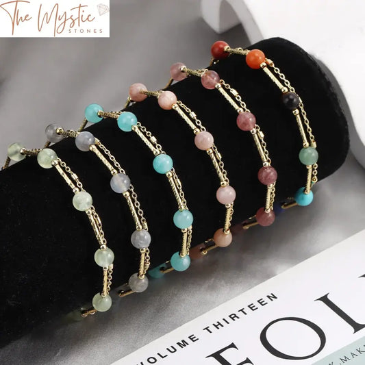 A double-layered bracelet featuring vibrant 7 chakra natural stones with gold-colored link chain accents.