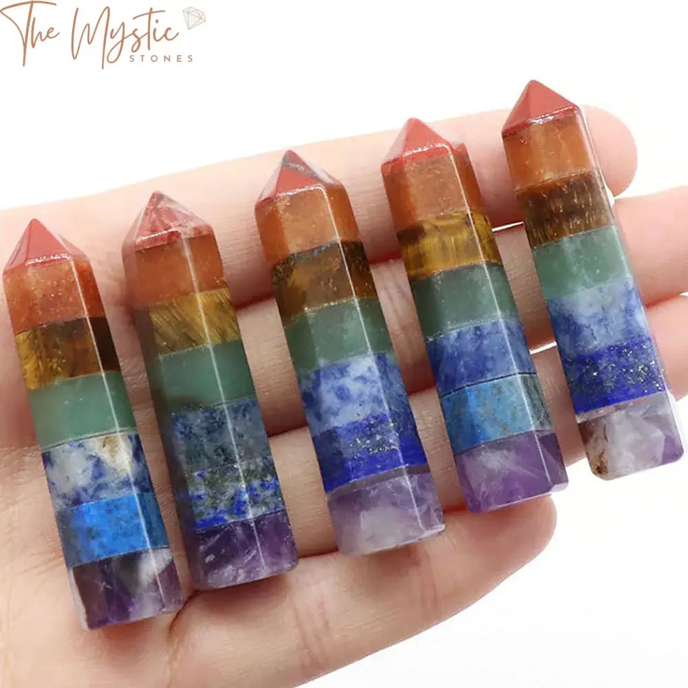 A set of seven hexagonal crystal wands, each representing one of the seven chakras, displayed in a row.