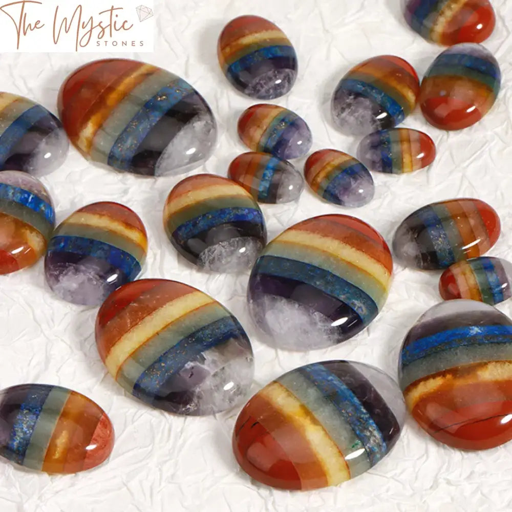 A collection of vibrant and polished natural stone cabochon beads, each representing one of the seven chakras.