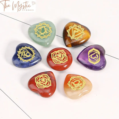 A set of seven round love heart-shaped beads, each adorned with engraved symbols representing the seven chakras.