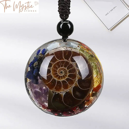 A necklace featuring a spiral-wrapped pendant with natural healing crystals representing the 7 chakras.