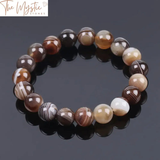 A collection of round gemstone bead bracelets featuring brown striped agate stones, each bead approximately 10mm in diameter.