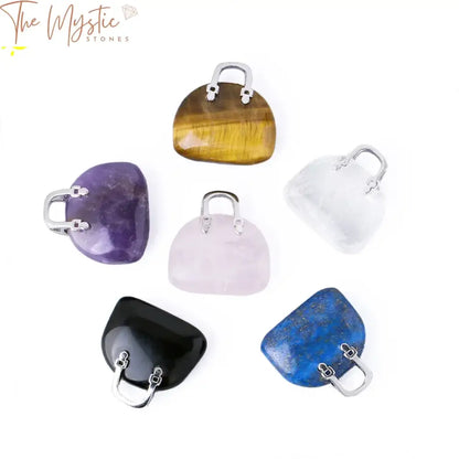 A collection of assorted, polished gemstone pendants displayed on a light surface.