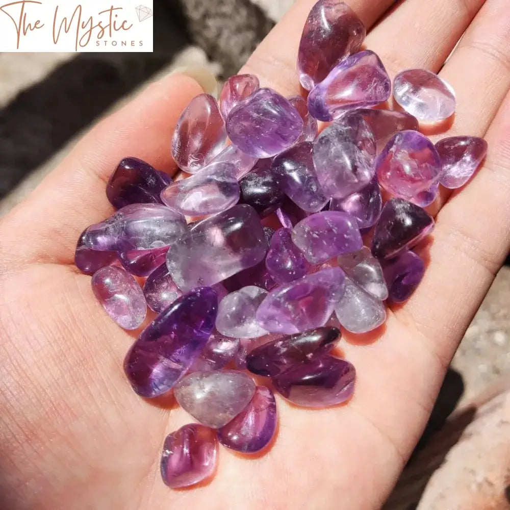 A collection of small, polished Amethyst crystal chips in varying shades of purple.