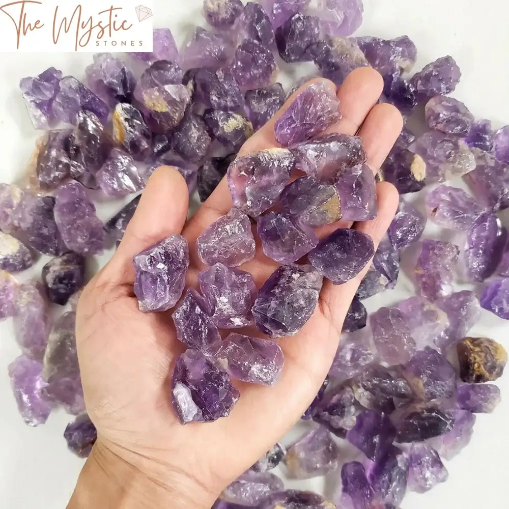 A collection of raw amethyst crystal chunks in various sizes, showcasing their natural purple hues and rough textures.