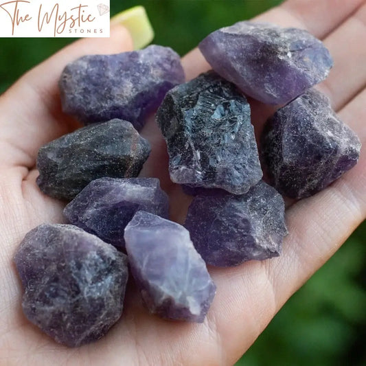 A collection of rough amethyst crystals with a variety of irregular shapes and sizes, displaying a vibrant purple hue.