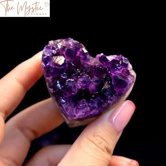 A heart-shaped amethyst crystal with a rich purple hue, showcasing a cluster of sparkling quartz formations.