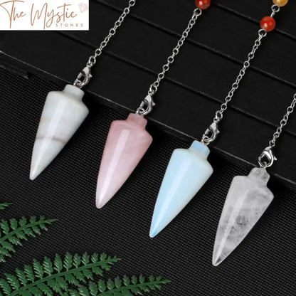 A clear quartz crystal pendulum with a conical shape, suspended by a delicate silver chain.