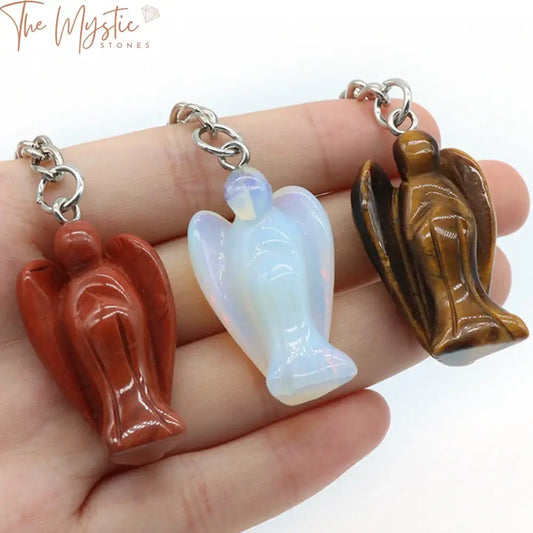 The image displays a collection of small angel figurine keychains, each intricately carved from various natural stones.