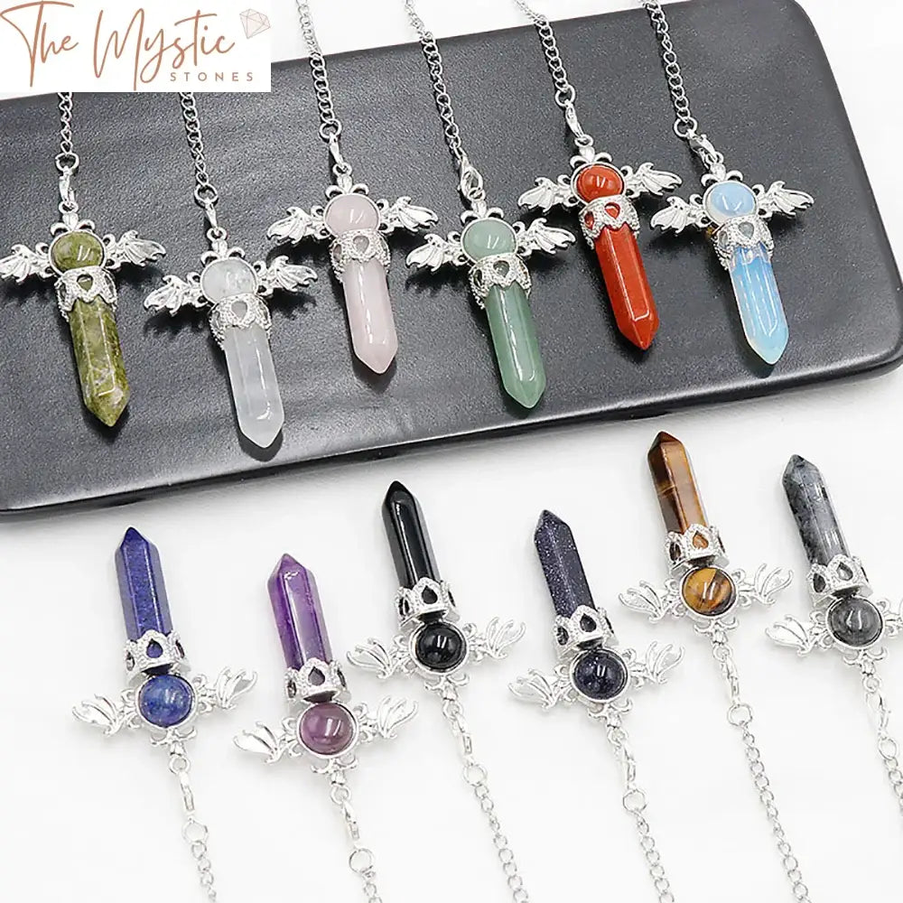 A pendulum featuring a six-faceted, hexagonal pointed gemstone with angel wing details, hanging from a decorative chain.