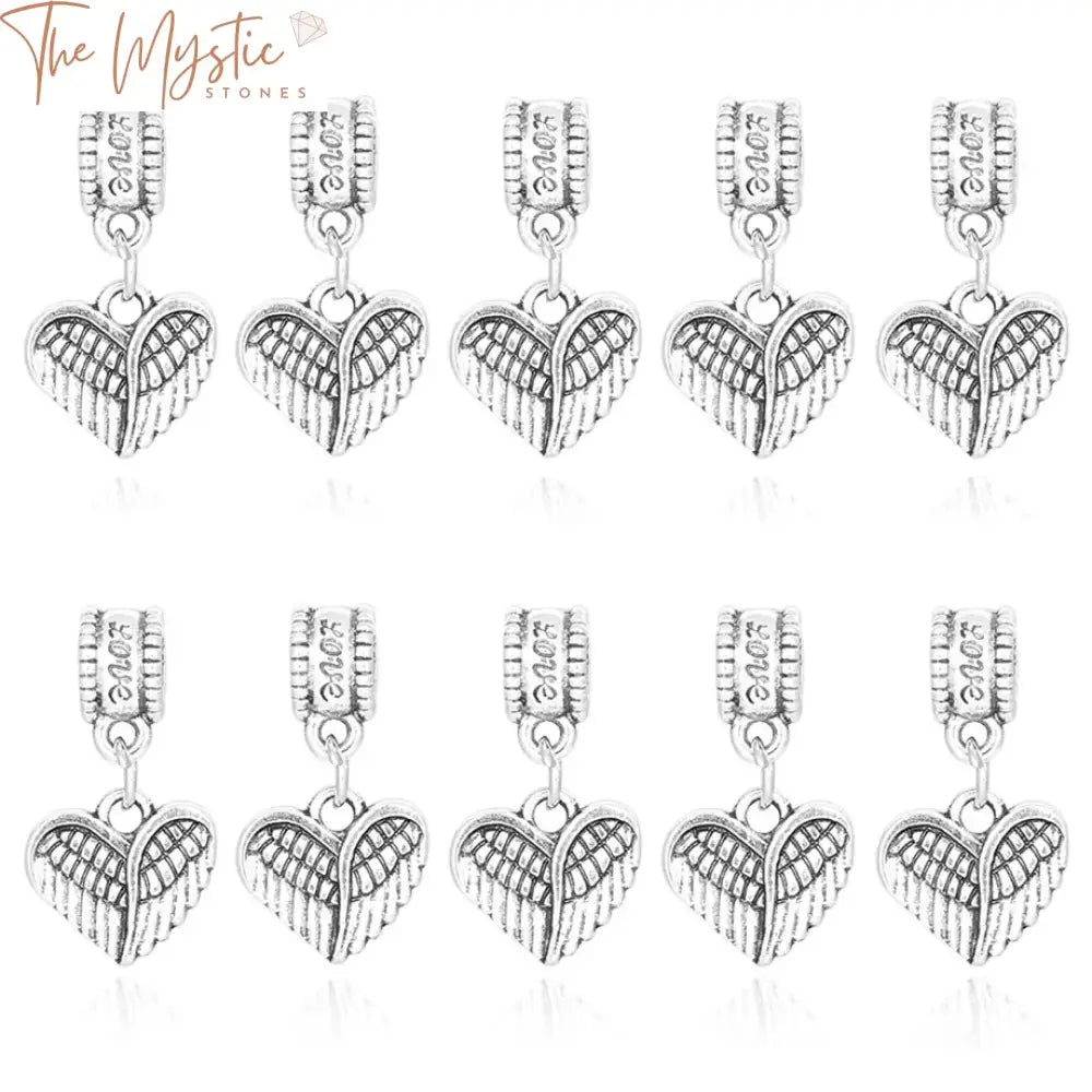 A collection of ten antique silver-colored beads featuring intricate heart-shaped angel wings design.