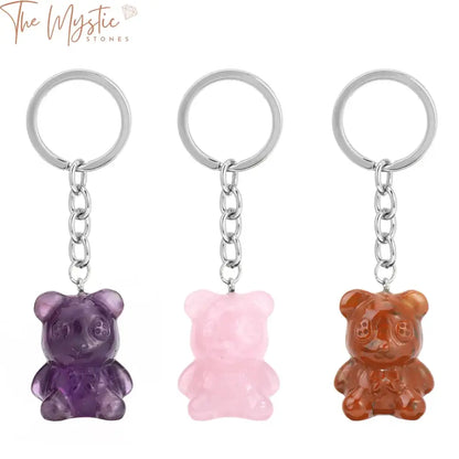 A close-up image of a keychain featuring a small, intricately carved bear made from natural stone.