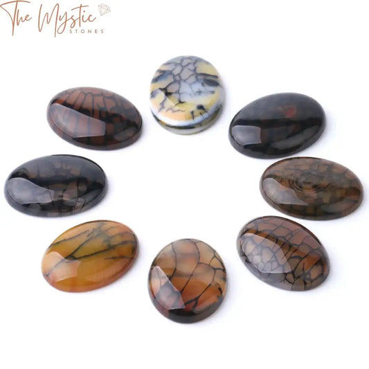 A collection of yellow and black dragon veins agate cabochon stones displayed on a flat surface.