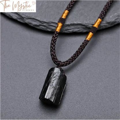 A natural black tourmaline stone pendant necklace featuring a polished, irregularly shaped black crystal.