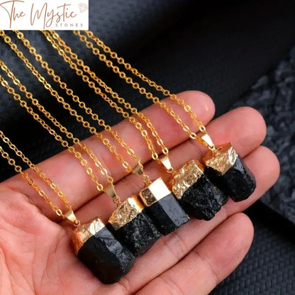 A collection of irregularly shaped black tourmaline stone pendants displayed against a plain white background.