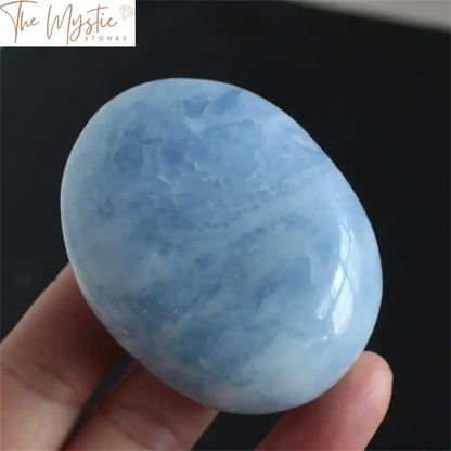 A collection of natural, polished blue celestite and angelite quartz crystals displayed on a wooden surface.