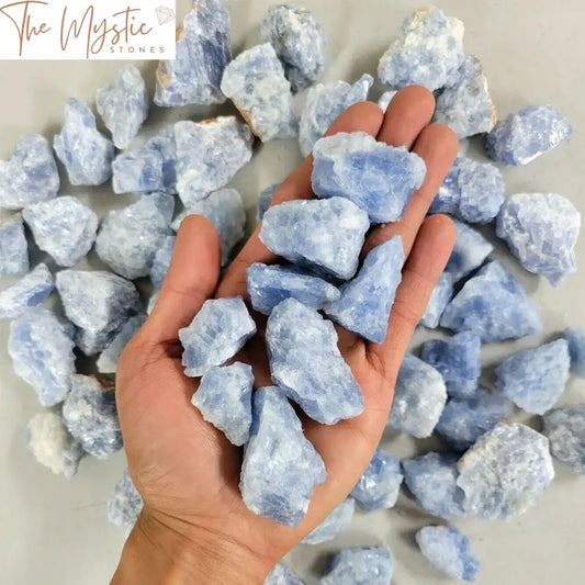 A collection of raw, rough blue celestite calcite crystals displayed against a neutral background.