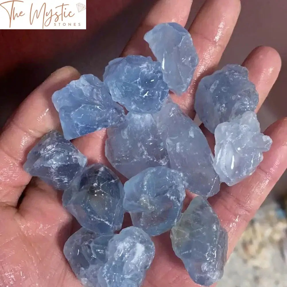 A collection of raw blue celestite chip rocks, varying in shades of light to medium blue, displayed on a neutral background.