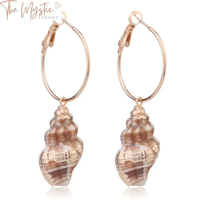 A pair of small hoop earrings with natural conch shell pendants hanging from each hoop, accented with a gold color finish.