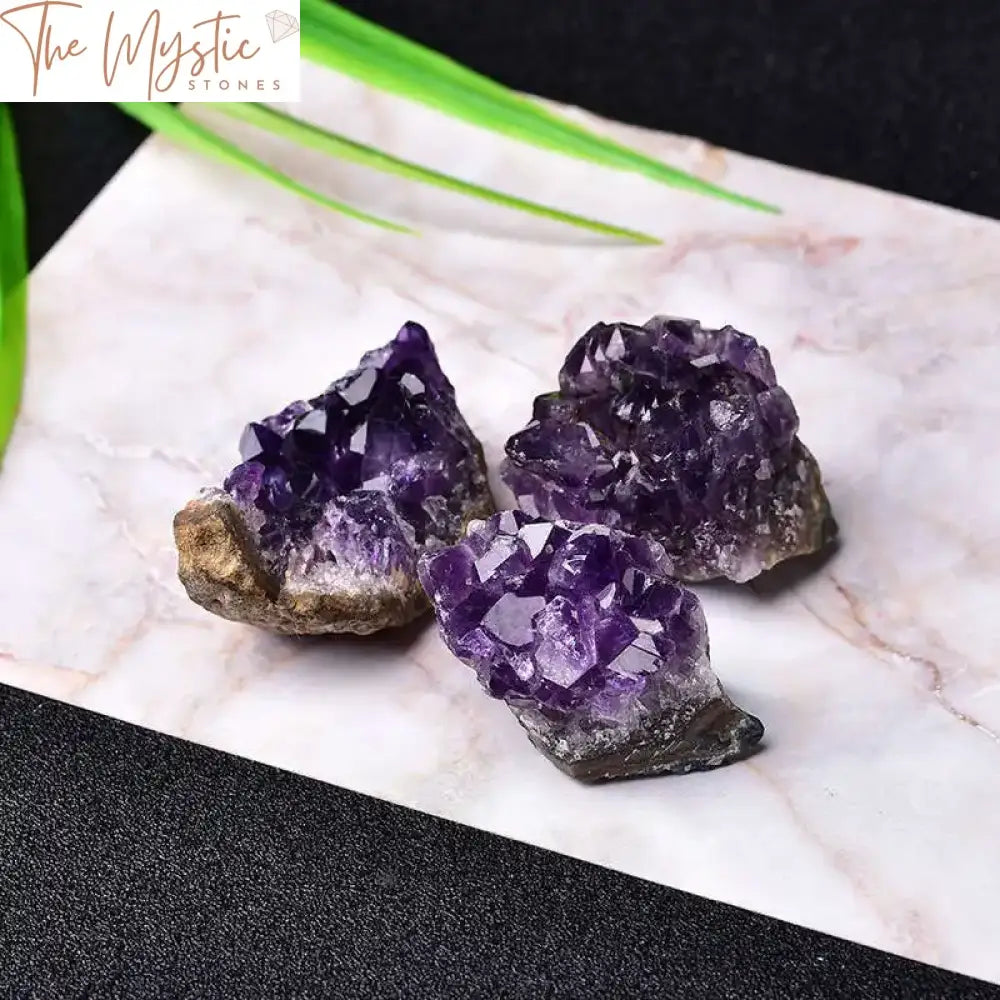 A small, natural quartz crystal specimen features a Brazilian amethyst cluster with druzy geode formations.