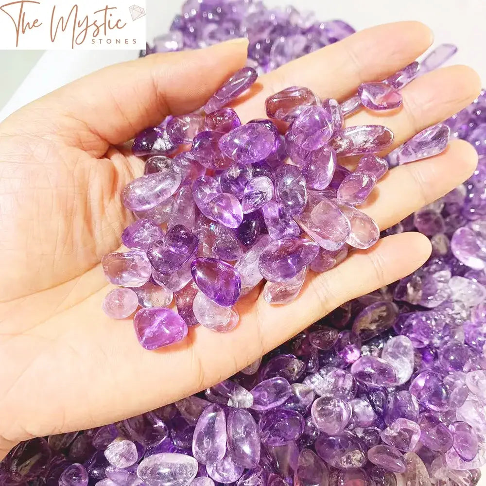 A close-up image of a pile of tumbled and crushed amethyst stones from Brazil, displaying various shades of purple.