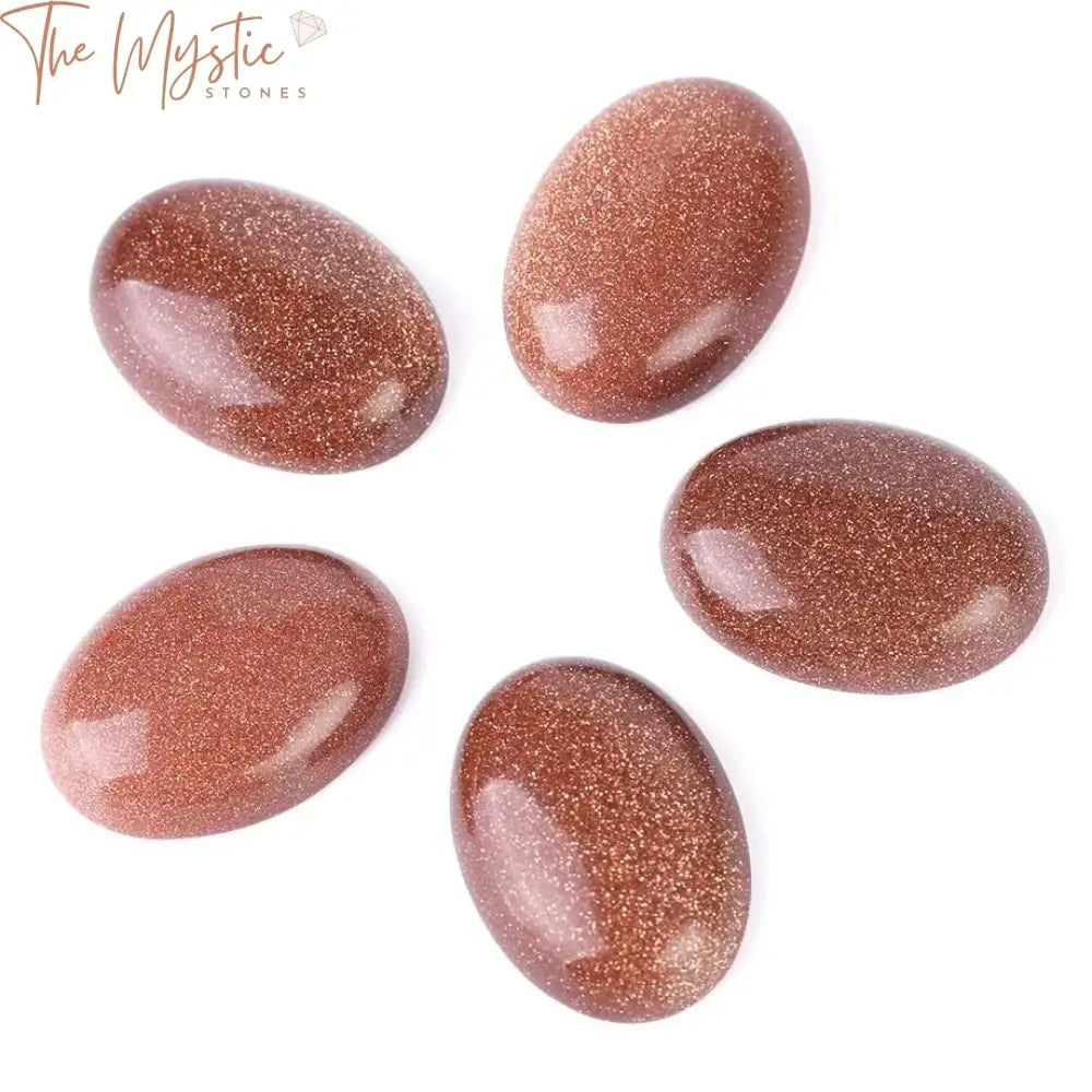 A collection of shiny brown sand cabochon beads, featuring an oval shape with a smooth, reflective surface.