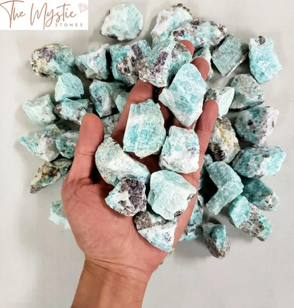 A collection of raw Amazonite crystals, showcasing their natural, rough shapes and vibrant blue-green hues.