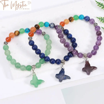 A vibrant bracelet featuring a string of natural stone beads representing the seven chakras, each bead a different color.