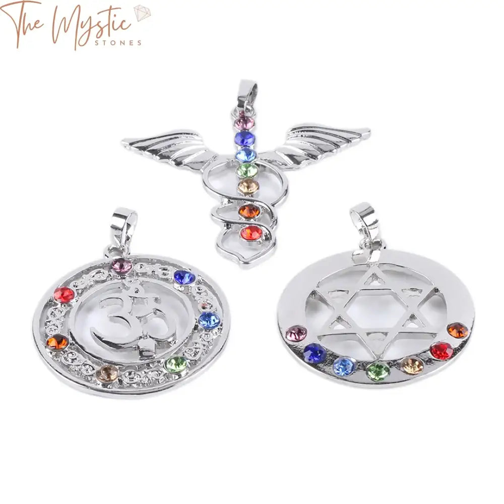 A collection of seven chakra-themed necklaces is displayed, each featuring a pendant adorned with rhinestones.