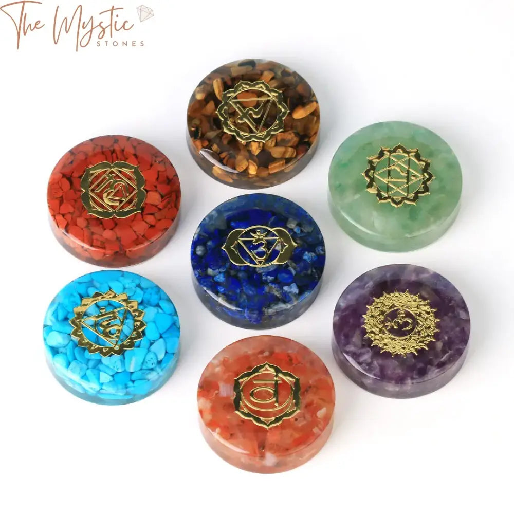 A set of vibrant chakra crystals arranged in a neat circle on a wooden surface.