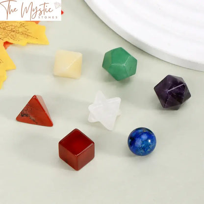 A set of seven natural chakra stones is displayed, each representing a distinct chakra.