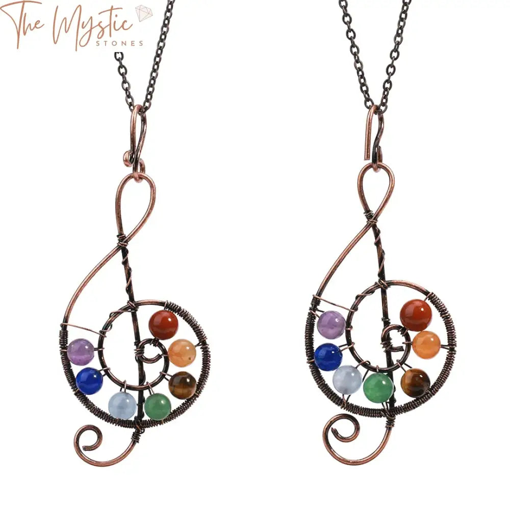 A close-up image of a pendant necklace featuring seven round beads, each representing a different chakra.