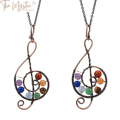 A close-up image of a pendant necklace featuring seven round beads, each representing a different chakra.