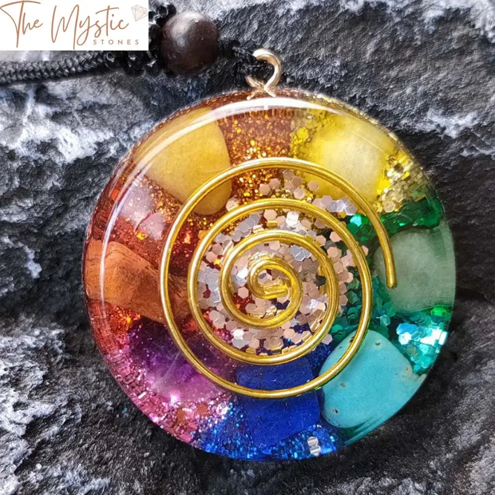 A pendant necklace featuring a teardrop-shaped orgonite with layered natural stones, symbolizing chakras, and copper spirals.