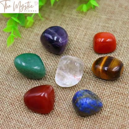 A set of seven colorful chakra stones arranged in a row, representing different energies.