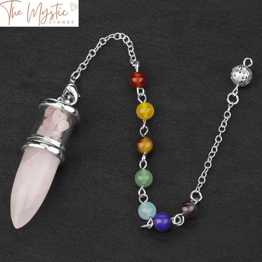 A bullet-shaped pendant crafted from natural stone is attached to a seven chakra chain.