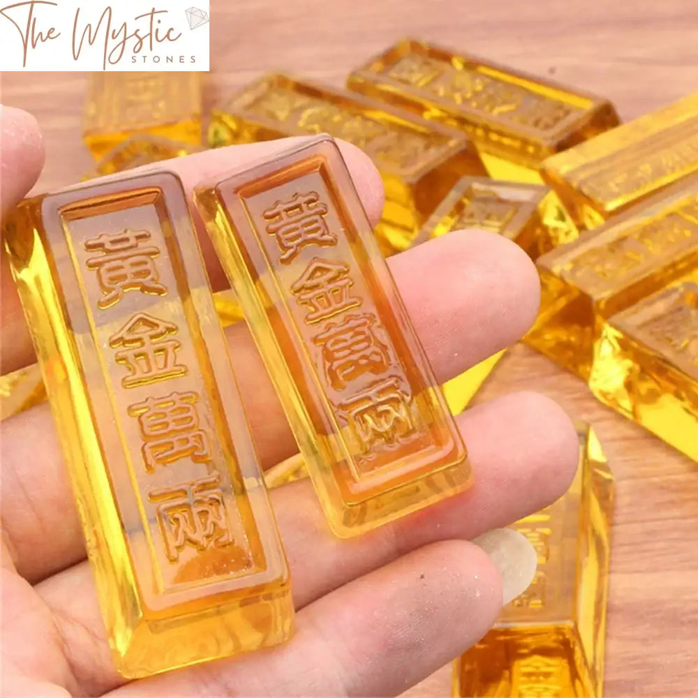 A close-up image of artificial crystal glass gold bars arranged in a neat stack, reflecting light from various angles.