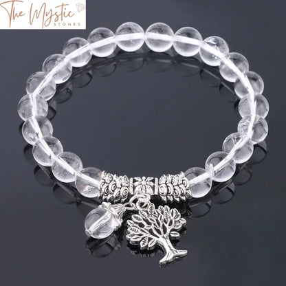 A delicate bracelet featuring 8mm natural stone clear crystal quartz beads, accented with a silver Tree of Life charm.