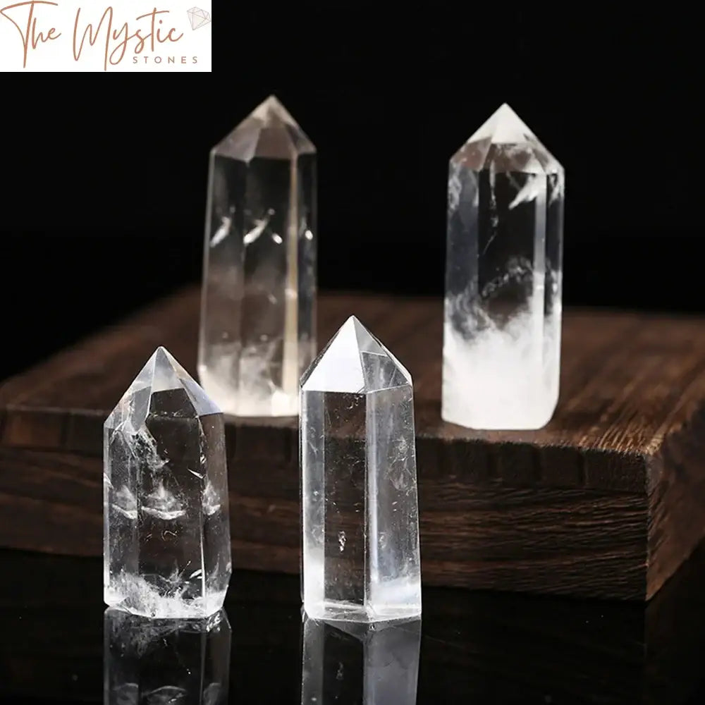 A clear quartz crystal obelisk wand with a pointed tip, showcasing its transparent and reflective surface that catches light.