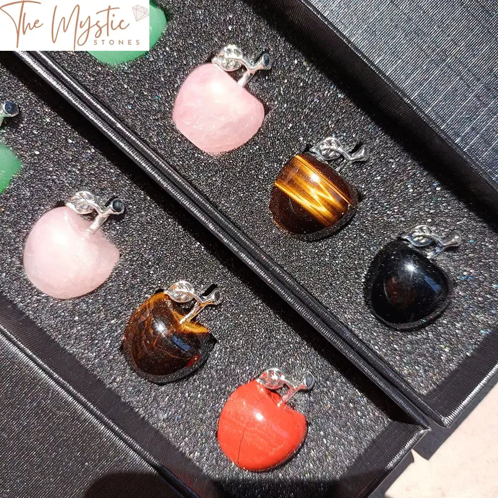 A set of seven small apple-shaped gemstones arranged in a neat row.