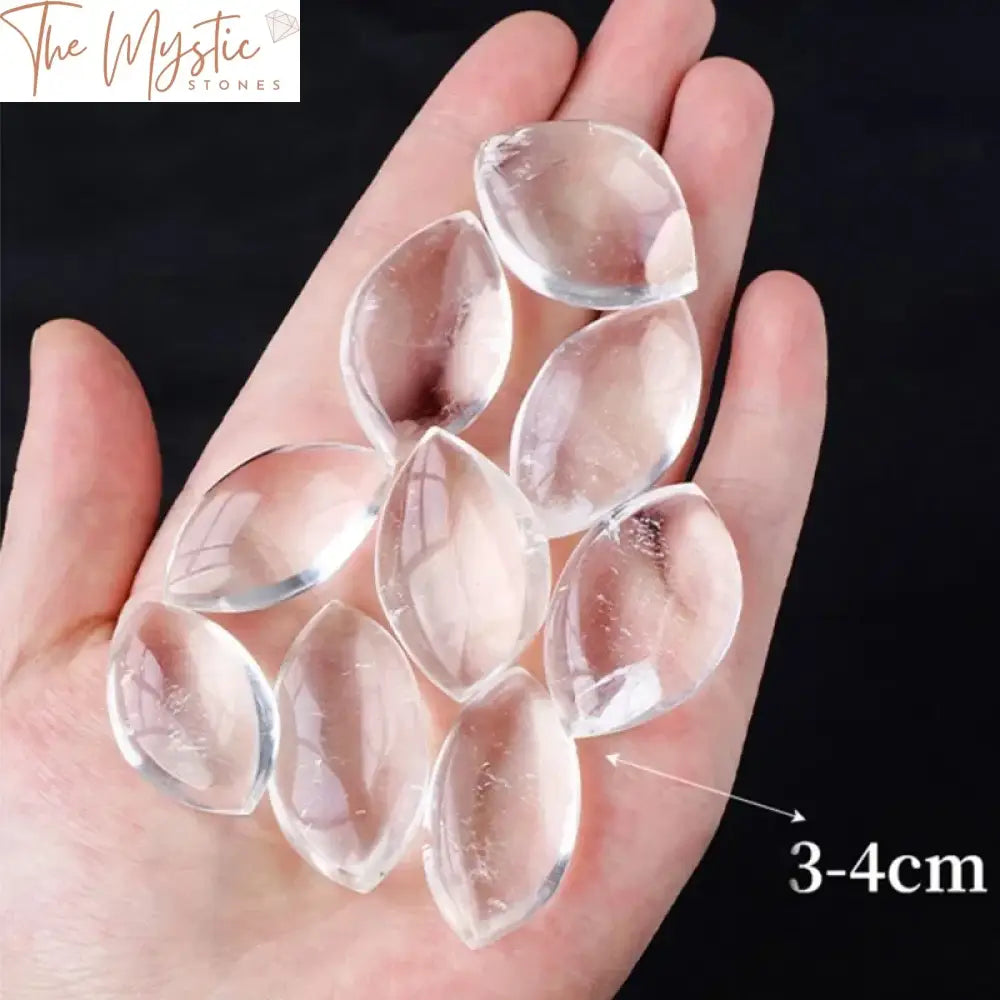 A collection of natural crystal clear quartz stones, each polished and shaped like a leaf, displayed together.