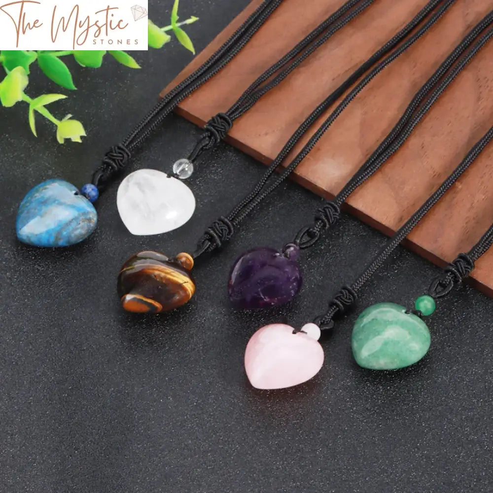 A heart-shaped crystal pendant made from dragon blood quartz hangs from a delicate nylon necklace.