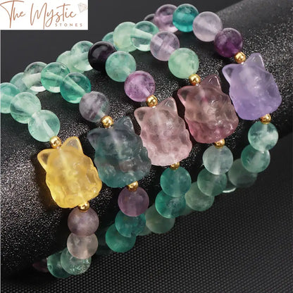 A bracelet made of 8mm natural fluorite beads with a carved fox charm, stretchy design, displayed on a plain background.