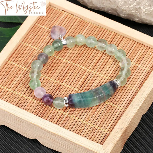 A Reiki Fluorite Crystal Bracelet featuring natural 8mm beads, a heart charm, and a stretchy mala design.