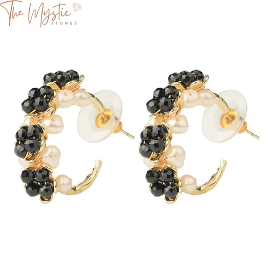 A pair of elegant gold-colored hoop earrings is adorned with natural stones and luxurious pearls.