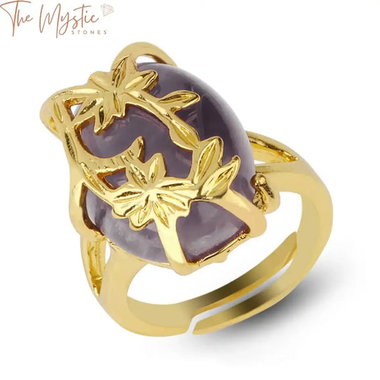 A gold-plated ring featuring a flower design, showcasing a polished, egg-shaped cabochon stone at its center.