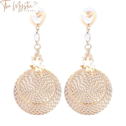 A pair of trendy metal stud earrings in a gold color featuring round pendants.